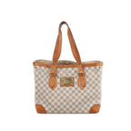 A cream and grey Louis Vuitton Hampstead MM shoulder bag in Damier Azur checkered canvas with tan leather straps and a central gold-tone logo plaque.