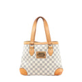 Louis Vuitton Hampstead PM Damier Azur tote handbag in beige and light blue checkered canvas with vachetta leather shoulder straps, leather corner trims, and a gold-tone front logo plaque, shown on a white background.