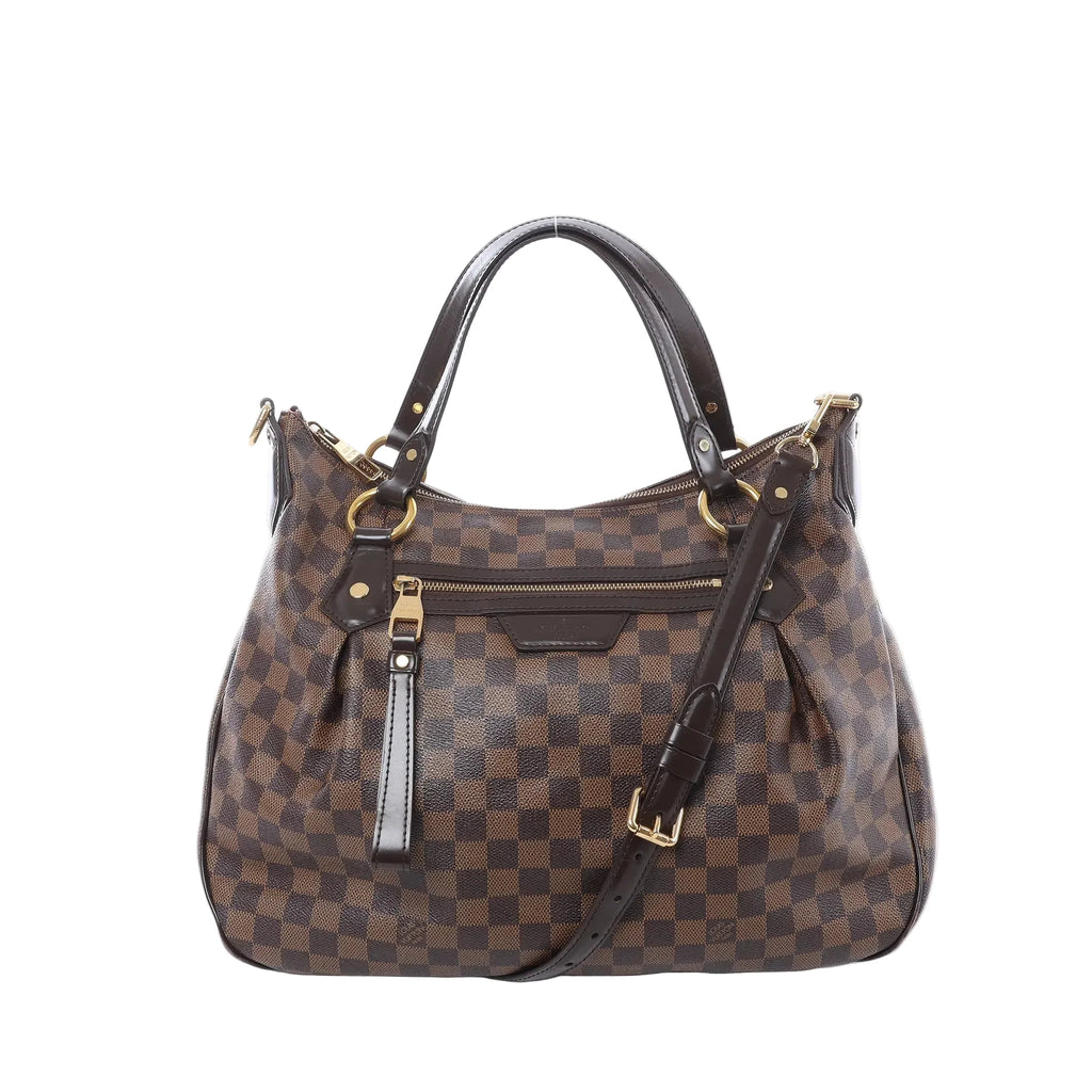 Louis Vuitton Ivorie MM shoulder bag in brown Damier Ebene canvas with dark leather top handles, detachable strap, gold-tone hardware, and front zip pocket on white background.
