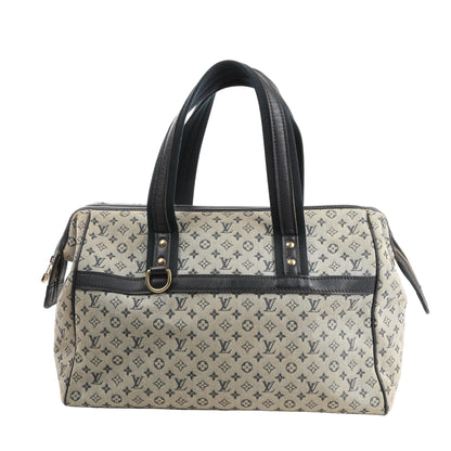 Front view of a Louis Vuitton Josephine GM handbag in beige Monogram Mini canvas with navy leather trim, dual rolled handles, gold-tone hardware, and side zipper details.