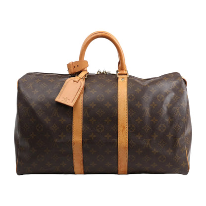 Louis Vuitton Monogram Canvas Keepall 45 Travel Bag M41428 featuring brown LV monogram canvas, tan leather handles and trim, gold-tone hardware, zip closure, and attached leather name tag, displayed on a white background.