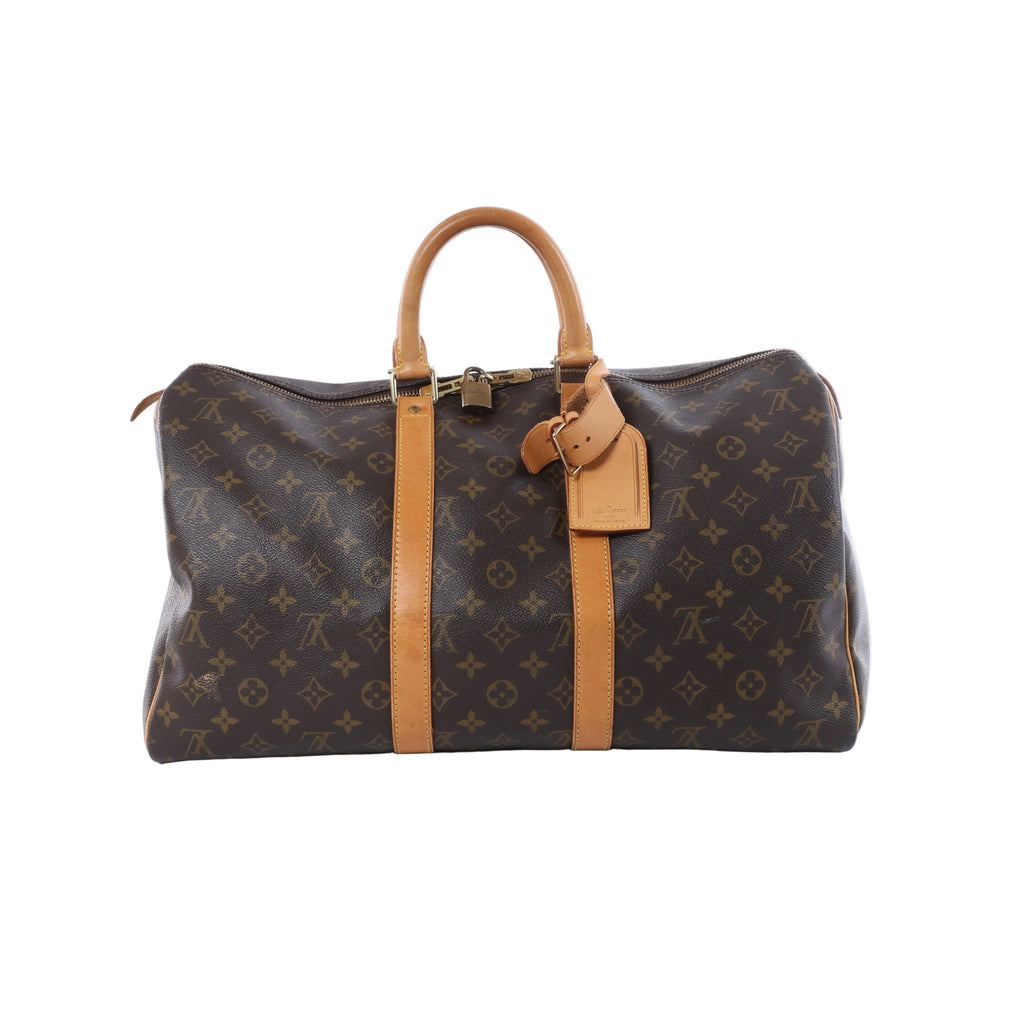 Brown Louis Vuitton Monogram Keepall 45 travel bag with tan leather handles, trim and luggage tag on a white background.