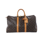 Brown Louis Vuitton Monogram Keepall 45 travel bag with tan leather handles, trim and luggage tag on a white background.