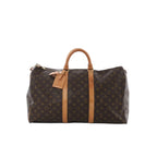 Louis Vuitton Keepall 50 Monogram canvas travel bag with tan leather handles and straps, top zip closure and padlock, front view on a white background.