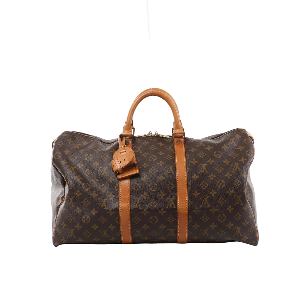 Louis Vuitton Keepall 50 Monogram canvas travel bag with tan leather top handles, vertical trim, luggage tag and gold-tone zip hardware.