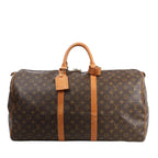 Louis Vuitton Keepall 55 M41424 travel bag in brown Monogram Canvas with natural cowhide leather handles, trim, and name tag, featuring a zip-top closure and spacious duffle silhouette for weekend or carry-on travel.