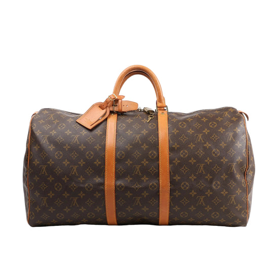 Louis Vuitton Monogram Canvas Keepall 55 Travel Bag M41424 featuring brown LV monogram canvas, tan leather handles and trim, gold-tone hardware, zip closure, and attached leather name tag, displayed on a white background.