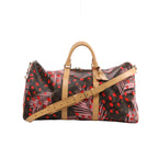 Louis Vuitton Keepall Bandoulière 50 with brown Monogram, pink palm leaves, red dots, tan leather handles and shoulder strap, and gold-tone hardware.