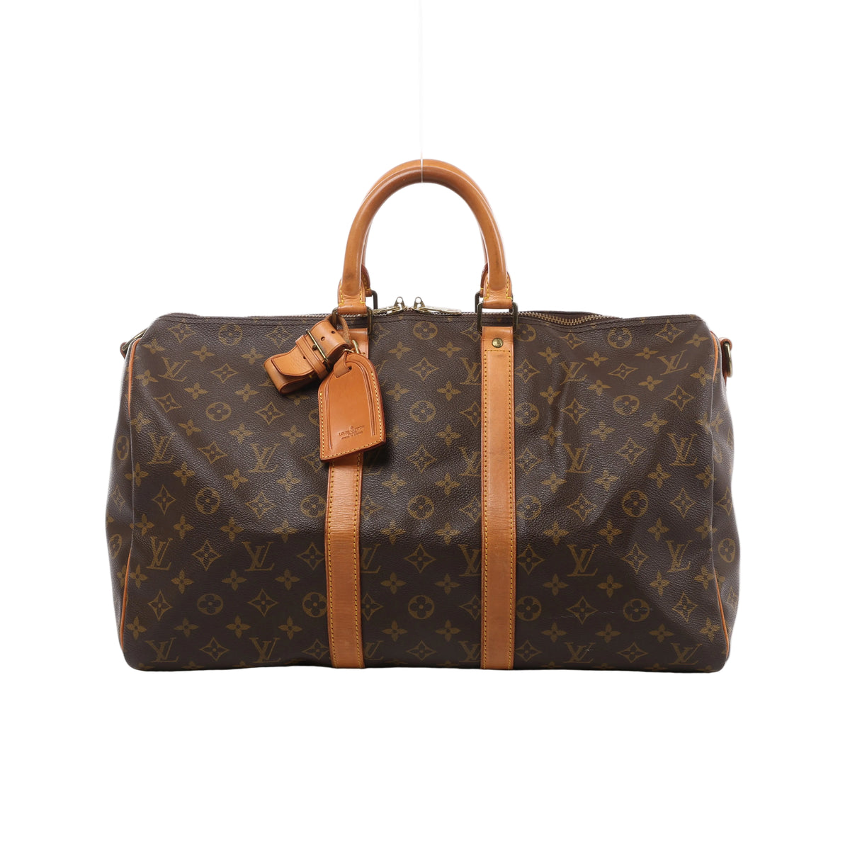 A brown Louis Vuitton Keepall Bandoulière 45 travel bag in Monogram coated canvas, featuring tan leather top handles, central leather trim, and an attached luggage tag.