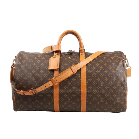 Louis Vuitton Monogram Canvas Keepall Bandoulière 55 Travel Bag M41414 featuring brown LV monogram canvas, tan leather handles, trim, and adjustable shoulder strap, gold-tone hardware, zip closure, and leather name tag, displayed on a white background.