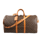 Louis Vuitton Monogram Canvas Keepall Bandoulière 55 Travel Bag M41414 featuring brown LV monogram canvas, tan leather handles, trim, and adjustable shoulder strap, gold-tone hardware, zip closure, and leather name tag, displayed on a white background.