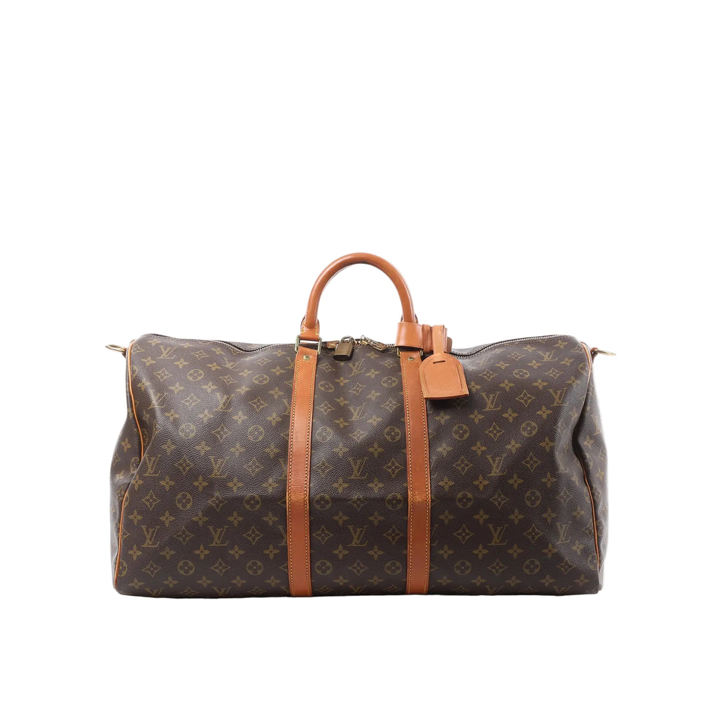 Front view of Louis Vuitton Monogram canvas Keepall 55 travel bag with tan leather handles, leather straps, luggage tag and padlock on a white background.