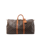 Front view of Louis Vuitton Monogram canvas Keepall 55 travel bag with tan leather handles, leather straps, luggage tag and padlock on a white background.