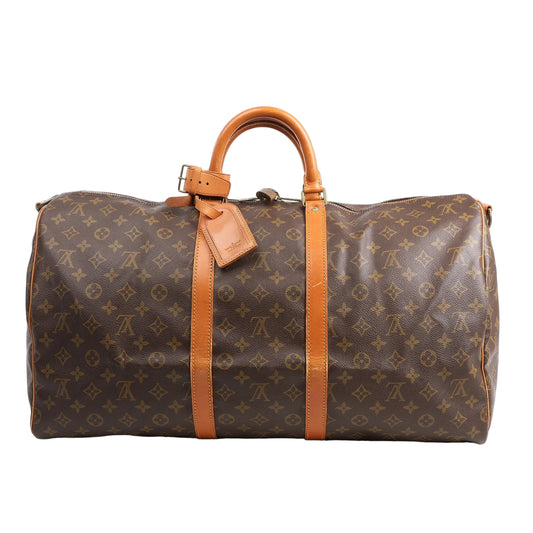 Louis Vuitton Monogram Canvas Keepall Bandoulière 55 Travel Bag M41414 featuring brown LV monogram canvas, tan leather handles and trim, gold-tone hardware, zip closure, and attached leather name tag, displayed on a white background without the shoulder strap.