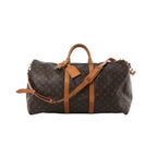 Louis Vuitton Keepall Bandoulière 55 Monogram canvas travel bag with vachetta leather trim, top handles, luggage tag, and detachable shoulder strap on white background.