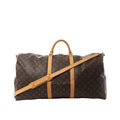 Louis Vuitton Keepall Bandoulière 60 brown Monogram canvas travel duffle with tan leather trim, top handles, detachable shoulder strap, and zip-top closure, front view on white background.