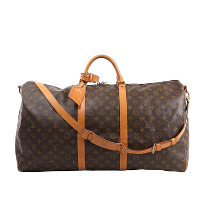 Louis Vuitton Monogram Canvas Keepall Bandoulière 60 Travel Bag M41412 featuring brown LV monogram canvas, tan leather handles, trim, and adjustable shoulder strap, gold-tone hardware, zip closure, and attached leather name tag, displayed on a white background.