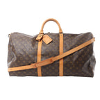 Louis Vuitton Monogram canvas Keepall Bandoulière 60 duffle bag with tan leather handles, luggage tag, and shoulder strap on white background