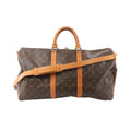 Louis Vuitton Monogram canvas Keepall Bandoulière 50 travel bag with tan leather handles, tan leather trim, top zip closure, and leather shoulder strap