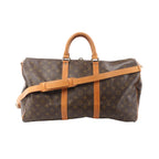 Louis Vuitton Monogram canvas Keepall Bandoulière 50 travel bag with tan leather handles, tan leather trim, top zip closure, and leather shoulder strap
