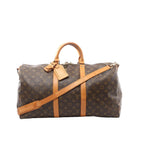 Louis Vuitton Keepall Bandoulière 50 brown Monogram canvas travel duffle with vachetta leather top handles, two vachetta leather bands, detachable shoulder strap, and top zip closure, shown on a white background.