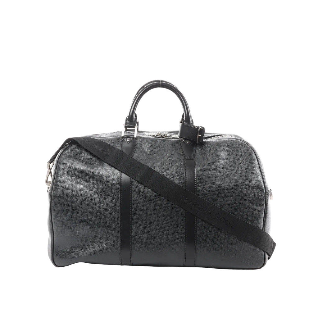 Black Louis Vuitton Kendall PM Taiga leather travel bag with double top handles, zip-top closure, and black shoulder strap.