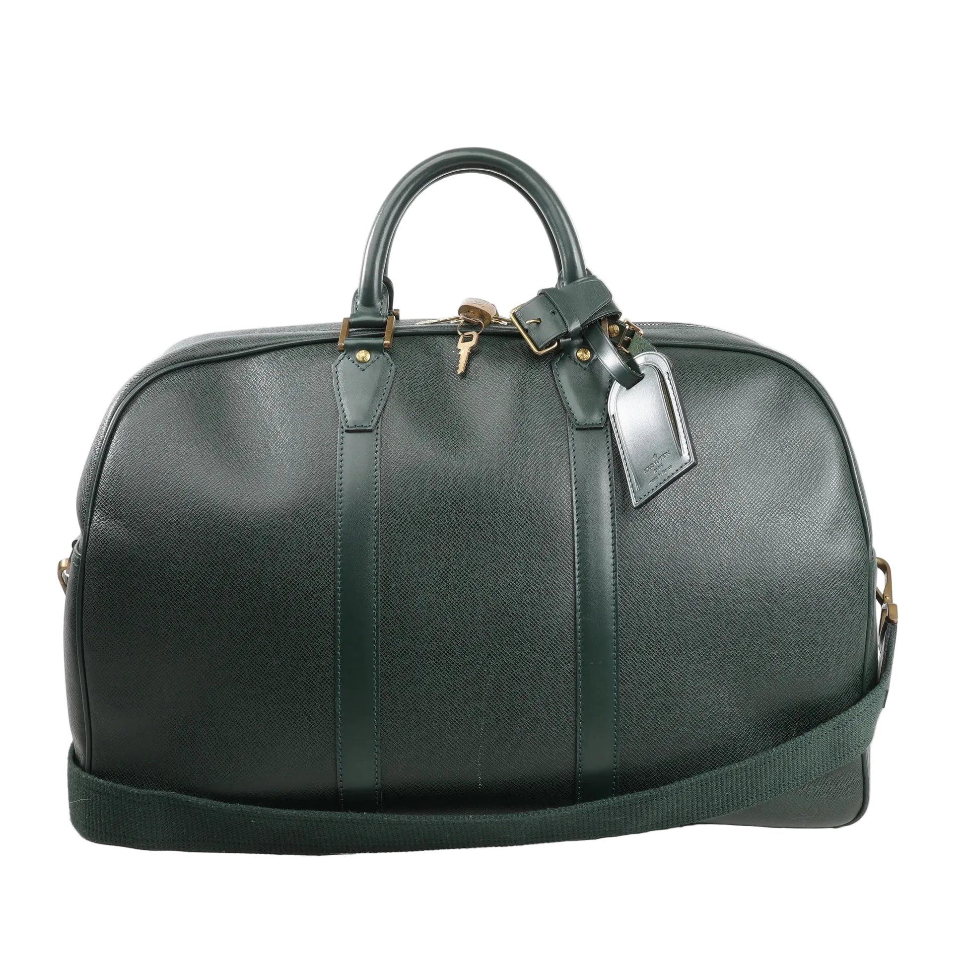 Louis Vuitton Kendall PM travel bag in deep green Taiga leather, featuring structured top handles, detachable shoulder strap, gold-tone hardware, and luggage tag detail.