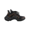 Side view of a Louis Vuitton LV Archlight sneaker with black mesh, brown Monogram panels, black laces and an oversized curved black sole.