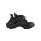 Side view of a Louis Vuitton LV Archlight sneaker with black mesh, brown Monogram panels, black laces and an oversized curved black sole.