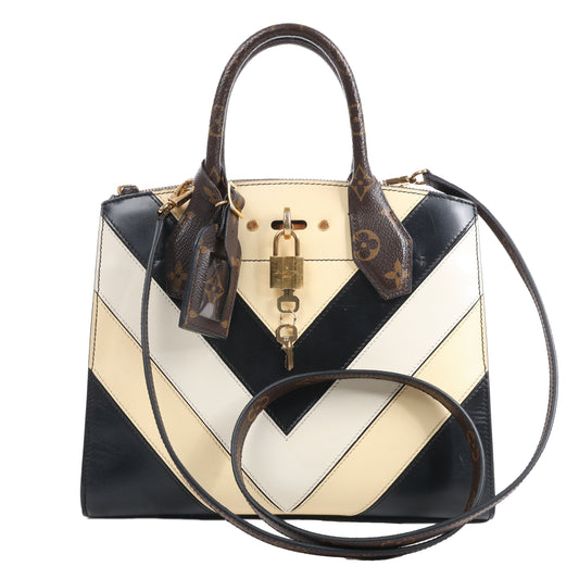 Designer handbag with black and white chevron pattern on a white background