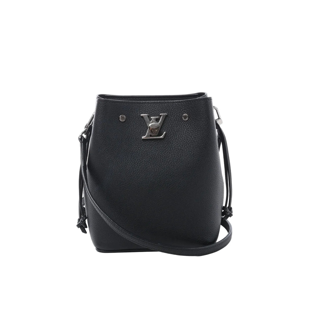 Louis Vuitton LockMe black grained leather bucket bag with silver-tone LV lock, drawstring side ties, slim crossbody strap and open top on white background.