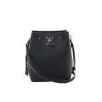 Louis Vuitton LockMe black grained leather bucket bag with silver-tone LV lock, drawstring side ties, slim crossbody strap and open top on white background.
