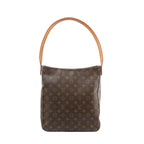 Louis Vuitton Looping GM shoulder bag in brown Monogram canvas with a curved tan vachetta leather loop handle, front view on white background.