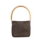 Louis Vuitton Looping MM brown Monogram canvas shoulder bag with a structured bucket shape and a large natural vachetta leather loop handle, shown on a white background.