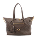 Front view of a brown Louis Vuitton Lumineuse PM bag with embossed Monogram leather, twin handles, a shoulder strap, front zip pocket and gold-tone hardware.