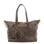 Front view of a brown Louis Vuitton Lumineuse PM bag with embossed Monogram leather, twin handles, a shoulder strap, front zip pocket and gold-tone hardware.