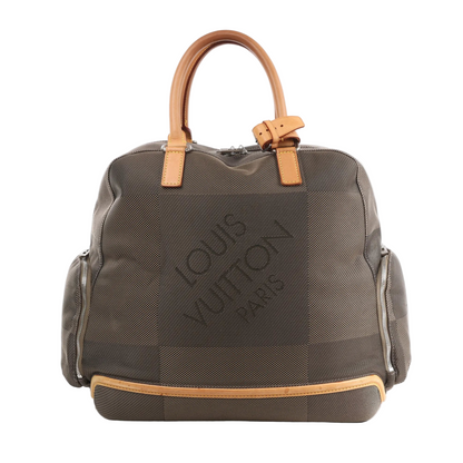 Front view of the Louis Vuitton Damier Geant Avanteurier Travel Bag M93061 in brown, featuring textured checkered canvas with oversized "Louis Vuitton Paris" lettering, natural leather handles and trim, and zippered side pockets, displayed against a white background.