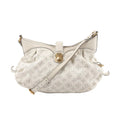 White Louis Vuitton Mahina XS bag in perforated Monogram leather with gathered silhouette, gold-tone front clasp, and adjustable shoulder strap.