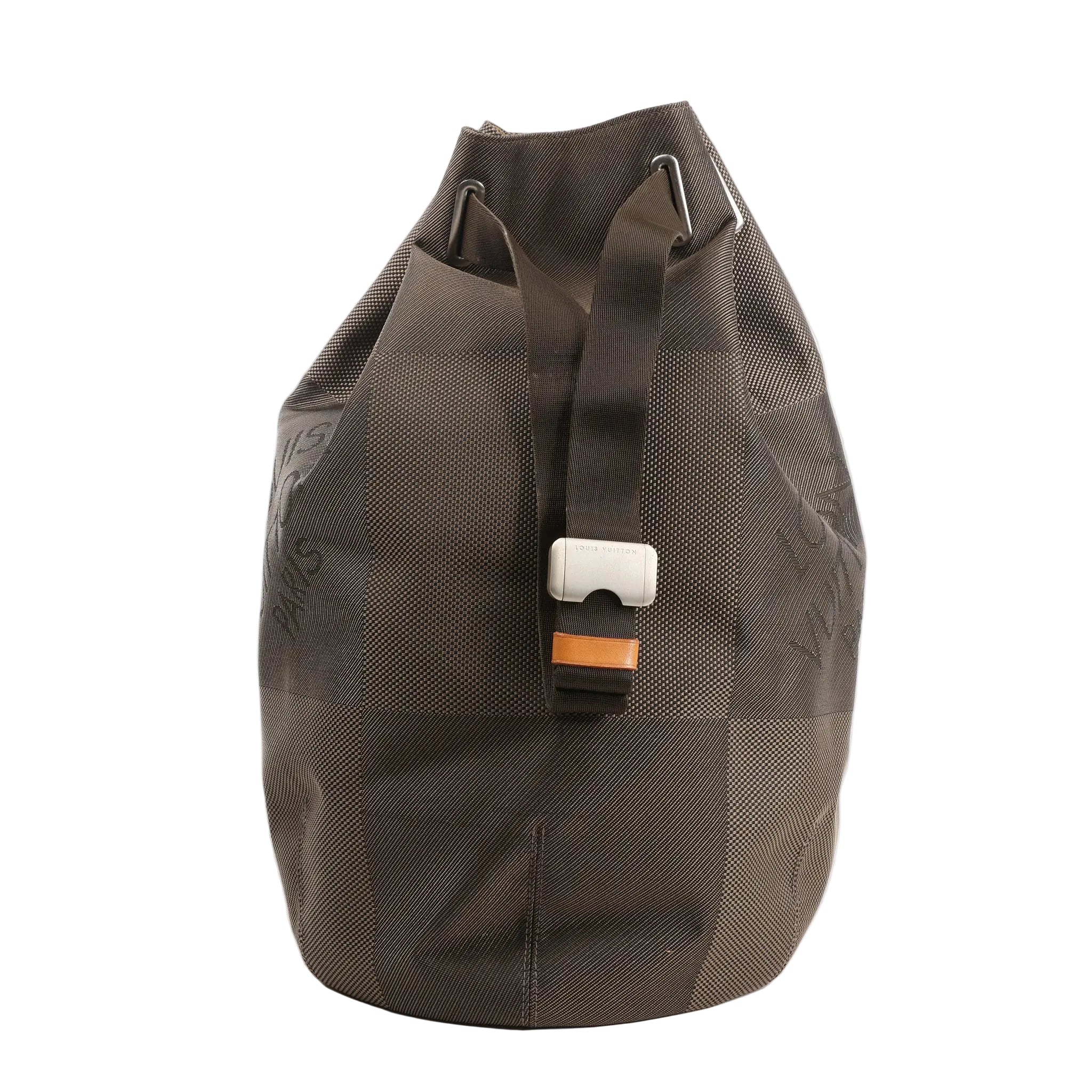 Louis Vuitton Matero PM shoulder bag in gray Damier Geant canvas with oversized check pattern, top drawstring closure, and adjustable web strap with silver-tone buckle.