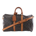 Louis Vuitton brown Monogram canvas travel bag with tan leather handles and trim, adjustable shoulder strap, top zipper and leather luggage tag.