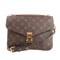Louis Vuitton Monogram Pochette Metis handbag in brown coated canvas with all-over LV monogram, gold-tone S-lock closure, adjustable leather strap, and top handle, shown against a white background.