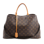 Louis Vuitton Montaigne GM 2Way Handbag M41067 in brown Monogram canvas with gold-tone hardware, natural cowhide top handles, removable shoulder strap, and key bell accent, displayed on a white background.