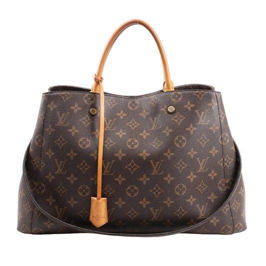 Louis Vuitton Montaigne GM 2Way Handbag M41067 in brown Monogram canvas with gold-tone hardware, natural cowhide top handles, removable shoulder strap, and key bell accent, displayed on a white background.