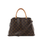 Louis Vuitton Montaigne MM brown Monogram canvas handbag with vachetta top handles and detachable shoulder strap on white background.