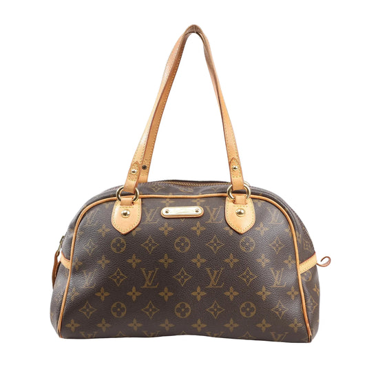 Louis Vuitton Montorgueil PM M95565 shoulder bag in brown Monogram coated canvas with natural leather trim, dual flat shoulder straps, gold-tone hardware, and LV nameplate on the front.