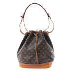 Louis Vuitton Noé brown Monogram canvas bucket bag with tan leather base, drawstring closure and adjustable shoulder strap.