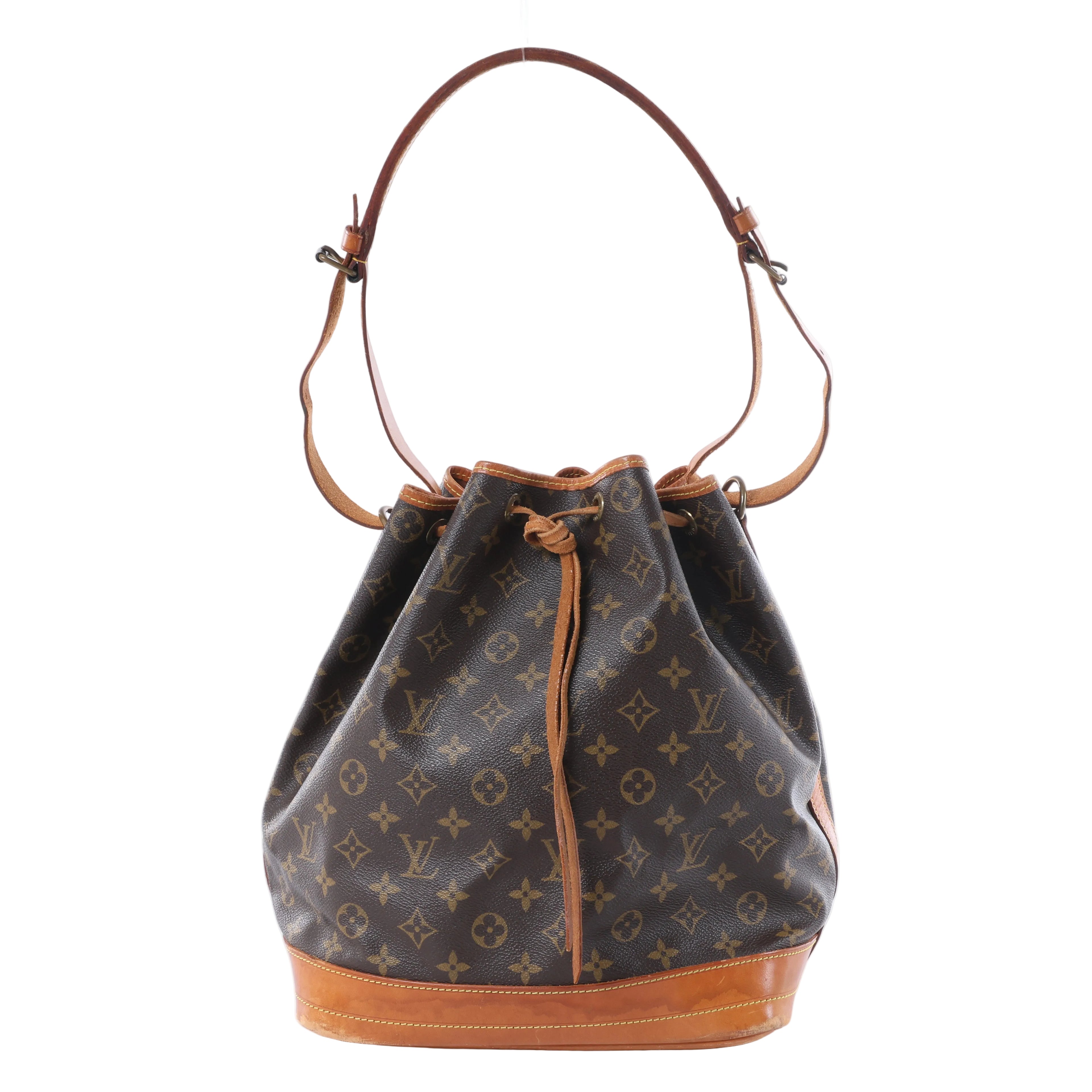 Louis Vuitton Noé brown Monogram canvas bucket bag with tan leather base, drawstring closure and adjustable shoulder strap.