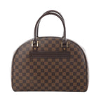 Louis Vuitton Nolita Damier Ebene handbag in brown checkered canvas with dark leather top handles and gold-tone hardware, front view on white background.