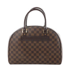 Louis Vuitton Nolita Damier Ebene handbag in brown checkered canvas with dark leather top handles and gold-tone hardware, front view on white background.