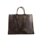Front view of Louis Vuitton OntheGo GM brown Giant Monogram tote with contrasting Monogram Reverse top handles and long black shoulder straps.
